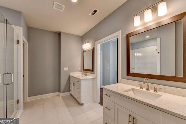 bathroom featuring two vanities, a shower stall, visible vents, and a sink