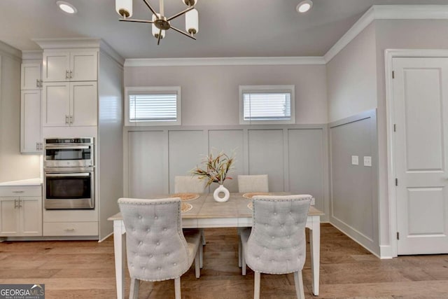 dining space with light hardwood / wood-style flooring, crown molding, and a wealth of natural light