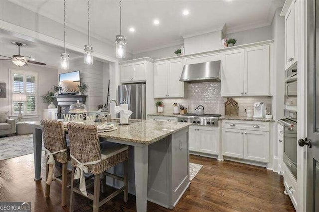 kitchen with stainless steel appliances, white cabinets, and exhaust hood