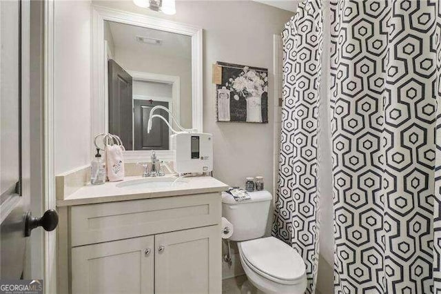 bathroom featuring vanity, a shower with shower curtain, and toilet