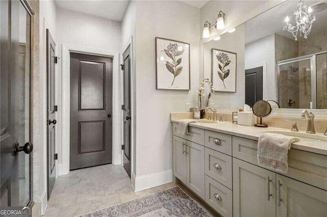 bathroom with a notable chandelier, vanity, and walk in shower