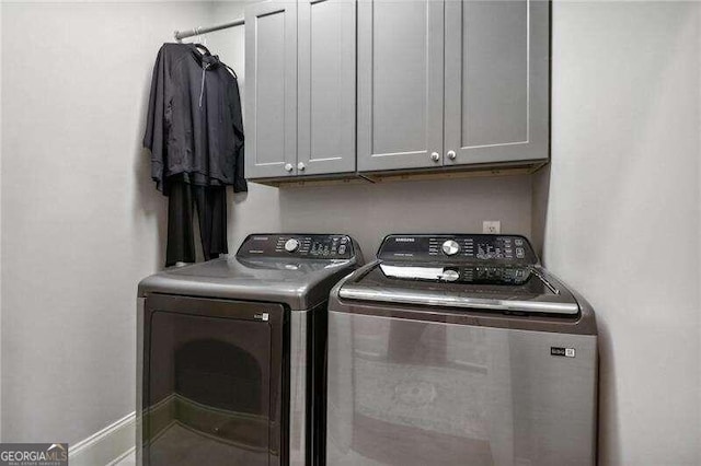 laundry area with cabinets and washing machine and dryer