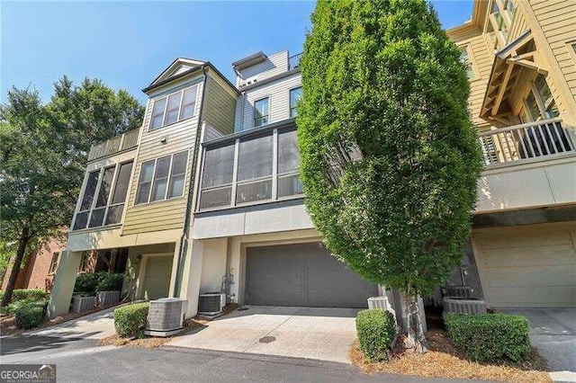 view of front of property with central AC unit and a garage