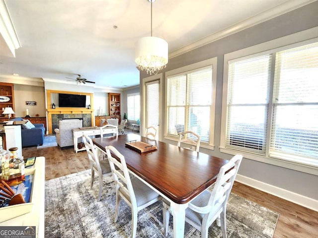 dining room featuring ornamental molding, dark wood-type flooring, and ceiling fan with notable chandelier