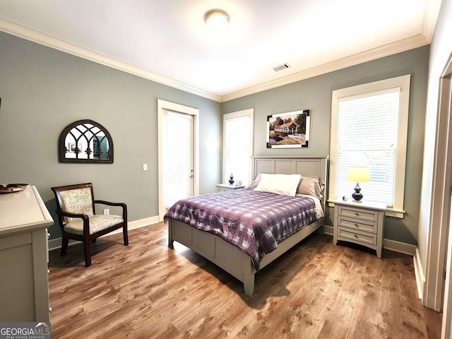 bedroom with crown molding, multiple windows, and light hardwood / wood-style floors