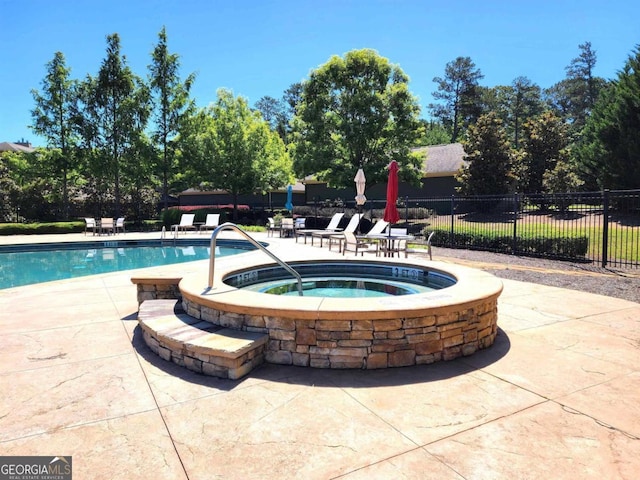 view of pool featuring an in ground hot tub and a patio area