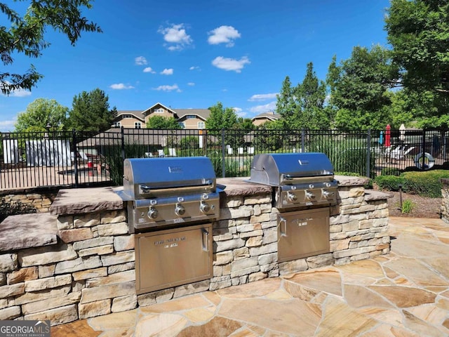 view of patio / terrace with an outdoor kitchen, grilling area, and fence