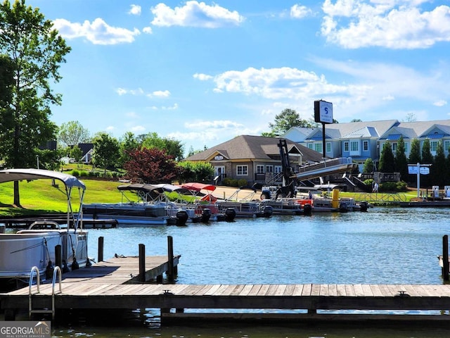 view of dock with a water view and a yard