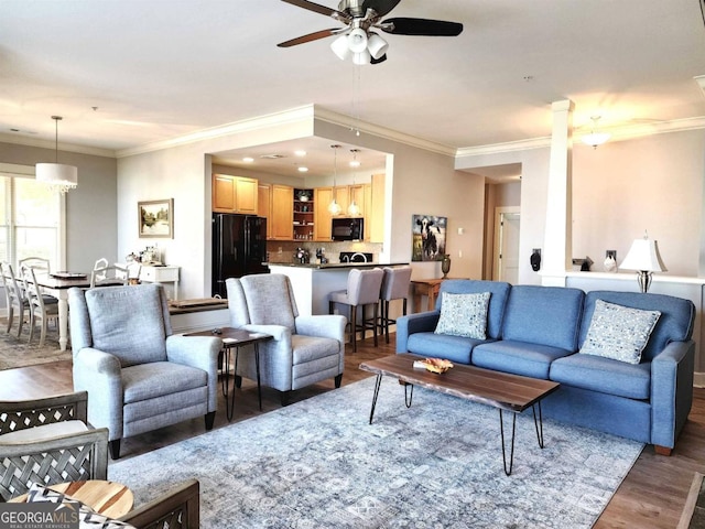 living room featuring ceiling fan, ornamental molding, and dark hardwood / wood-style flooring