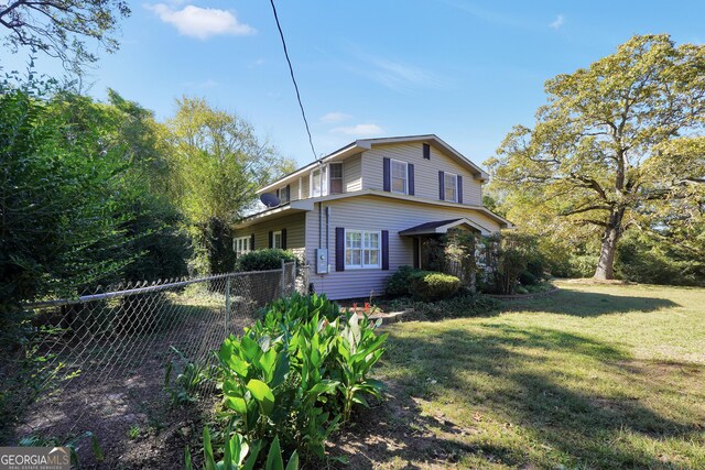 view of side of home with a yard