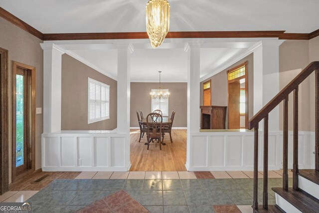 entrance foyer with tile patterned flooring, a chandelier, and ornamental molding