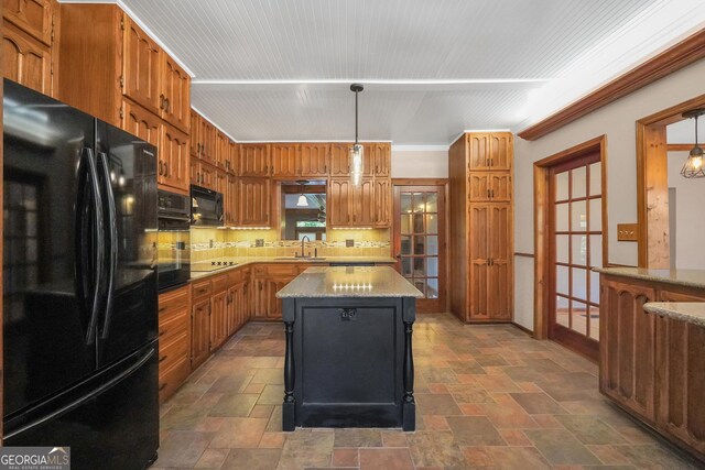 kitchen with a center island, crown molding, pendant lighting, decorative backsplash, and black appliances