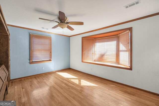 unfurnished room with ceiling fan, light hardwood / wood-style floors, and crown molding