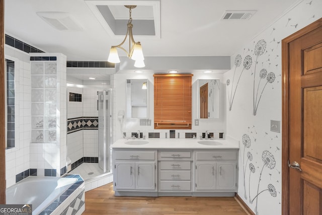 bathroom with vanity, crown molding, plus walk in shower, hardwood / wood-style floors, and a chandelier