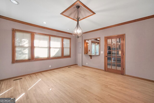 unfurnished room featuring a chandelier, light hardwood / wood-style flooring, and ornamental molding