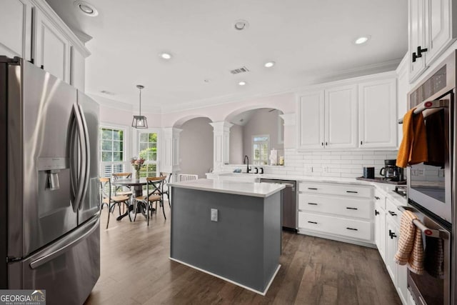 kitchen featuring hanging light fixtures, a center island, white cabinets, and stainless steel appliances