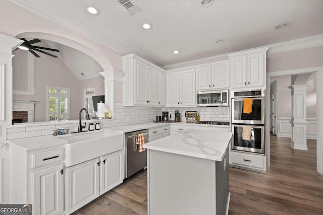 kitchen featuring dark wood-type flooring, white cabinets, ceiling fan, kitchen peninsula, and stainless steel appliances