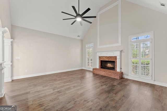 unfurnished living room featuring hardwood / wood-style floors, ceiling fan, a healthy amount of sunlight, and high vaulted ceiling