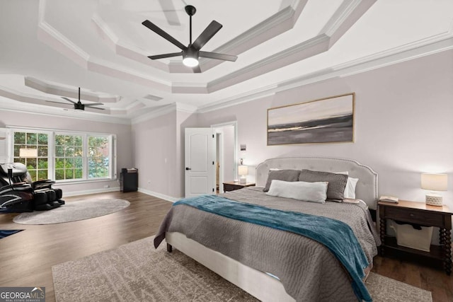 bedroom featuring dark hardwood / wood-style floors, a raised ceiling, and ornamental molding