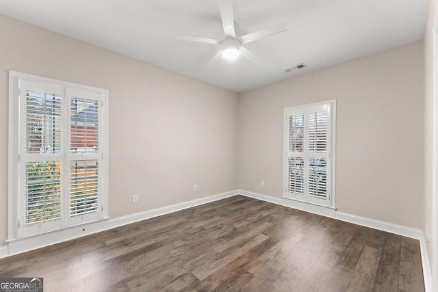 empty room with ceiling fan and dark wood-type flooring