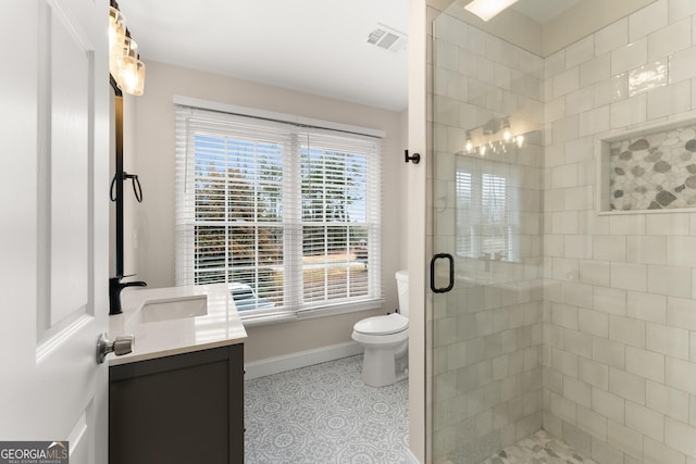 bathroom featuring tile patterned floors, vanity, toilet, and a shower with door