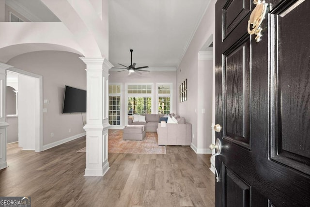 entrance foyer with decorative columns, ceiling fan, light hardwood / wood-style flooring, and crown molding