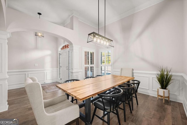 dining area with ornate columns, dark wood-type flooring, and ornamental molding