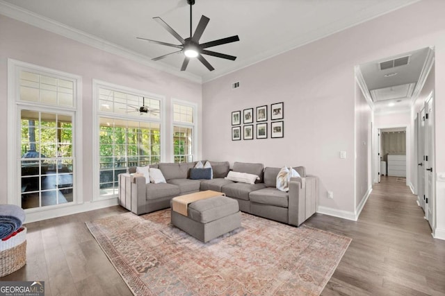 living room featuring crown molding, a towering ceiling, ceiling fan, and hardwood / wood-style flooring