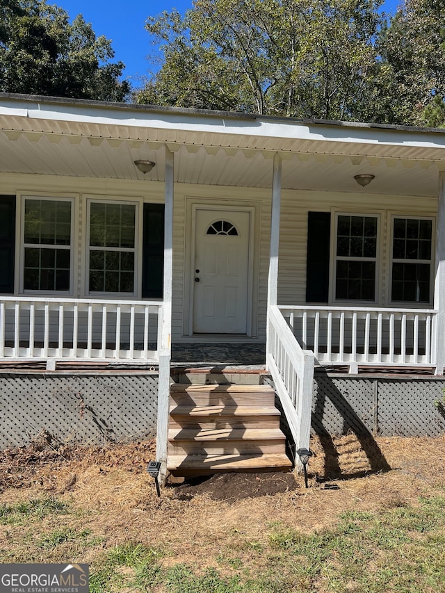 view of exterior entry with a porch