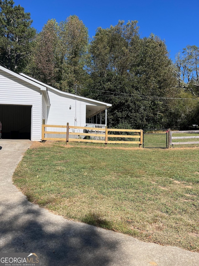 view of home's exterior featuring a yard, driveway, and fence