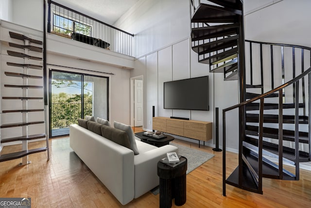 living room with a textured ceiling, wood-type flooring, and a towering ceiling