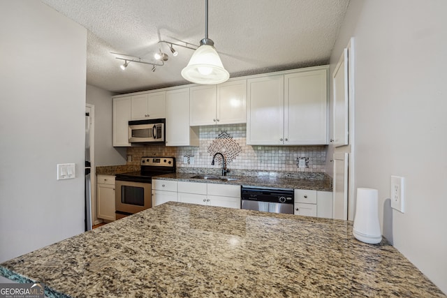 kitchen featuring a textured ceiling, appliances with stainless steel finishes, sink, and white cabinets