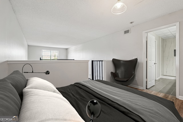 bedroom featuring a textured ceiling and hardwood / wood-style flooring