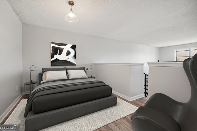 bedroom featuring a textured ceiling and hardwood / wood-style floors