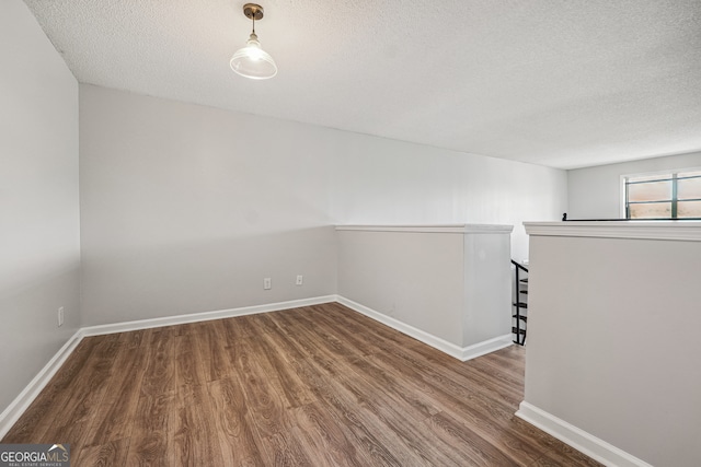 spare room with a textured ceiling and wood-type flooring