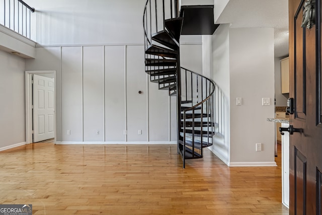 foyer entrance featuring light hardwood / wood-style flooring and a towering ceiling