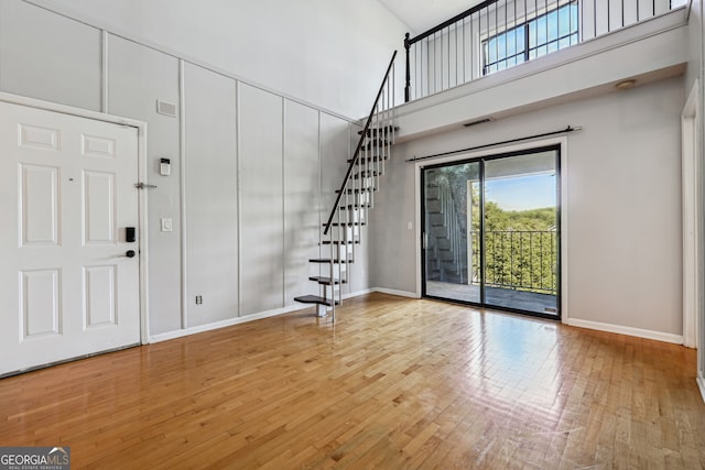 entryway featuring wood-type flooring and a high ceiling