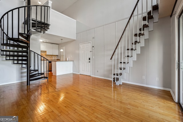 interior space with a towering ceiling and light wood-type flooring