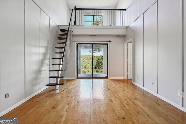 foyer entrance featuring a high ceiling and light hardwood / wood-style floors