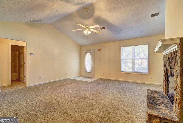 unfurnished living room featuring lofted ceiling, a textured ceiling, a fireplace, and ceiling fan