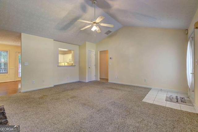 unfurnished living room with lofted ceiling, a textured ceiling, light colored carpet, and ceiling fan