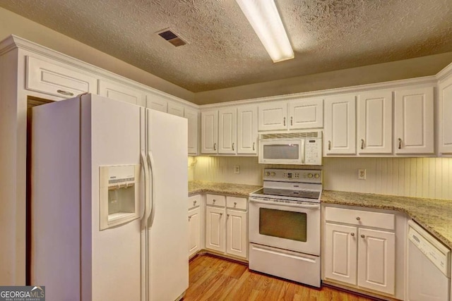 kitchen with white cabinets, light hardwood / wood-style flooring, a textured ceiling, and white appliances