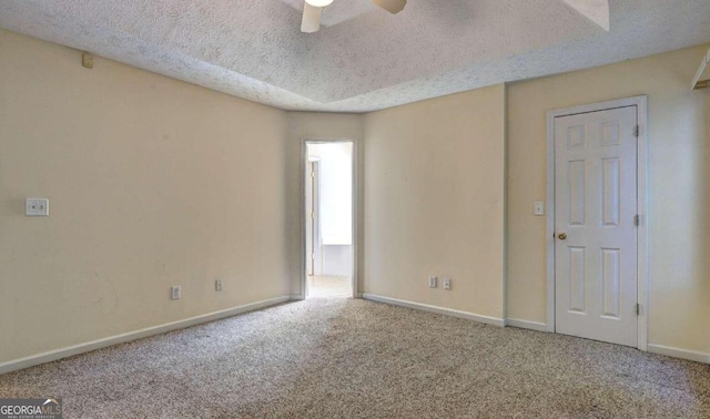 carpeted spare room featuring a textured ceiling and ceiling fan