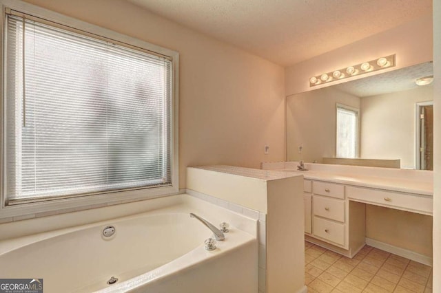 bathroom featuring vanity, a textured ceiling, a bath, and tile patterned floors