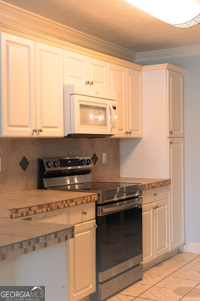 kitchen featuring ornamental molding, decorative backsplash, white cabinets, and electric stove