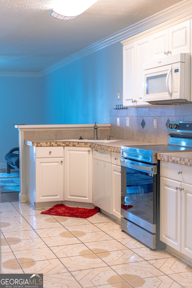 kitchen with white cabinets, backsplash, crown molding, sink, and white appliances