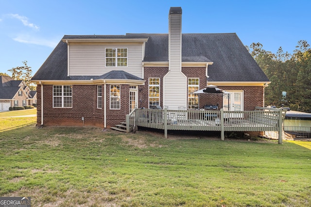 rear view of house with a yard and a wooden deck