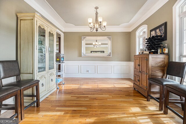 sitting room with crown molding, light hardwood / wood-style flooring, and a chandelier