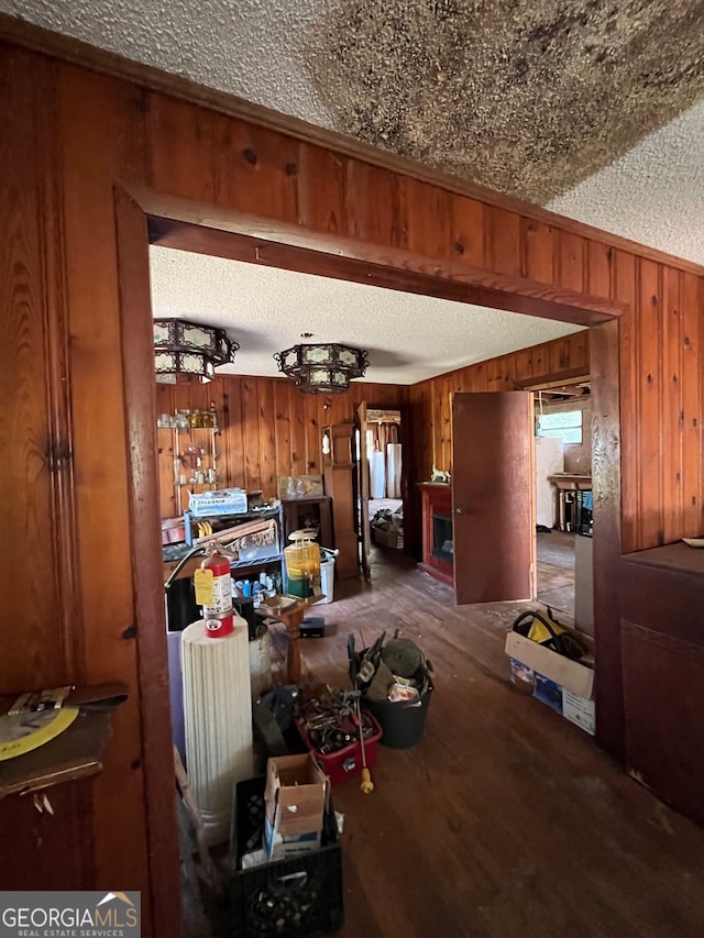 dining room with wood walls, a textured ceiling, and wood-type flooring