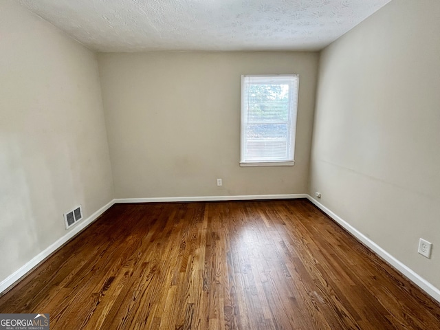 unfurnished room with hardwood / wood-style floors and a textured ceiling